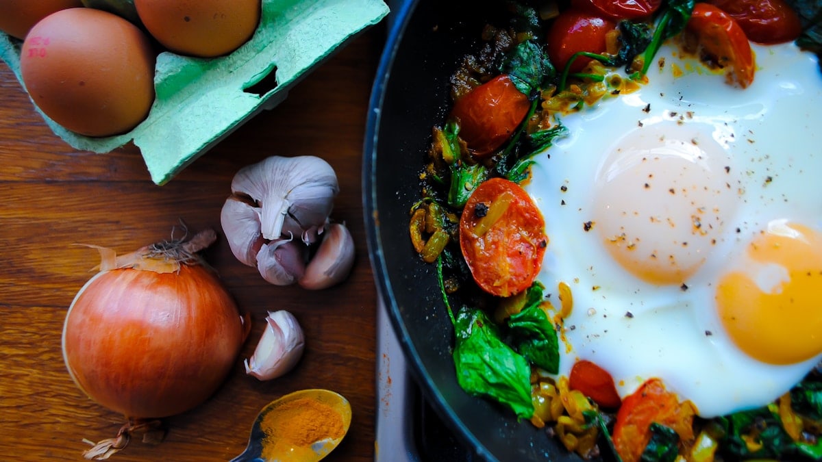 Healthy breakfast. Fried eggs with spinach and tomatoes.