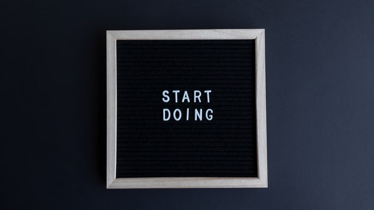 Black letter board with the motivational phrase 'Start Doing' in white text on a gray background.